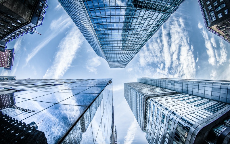 low angle photo of four high rise curtain wall buildings