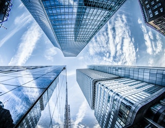 Low angle photo of four high rise curtain wall buildings