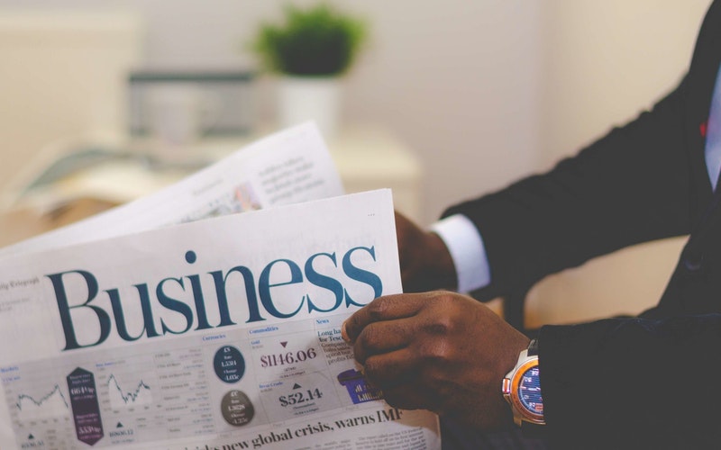 Person holding white and-blue business paper-post