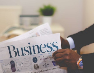 person-holding-white-and-blue-business-paper