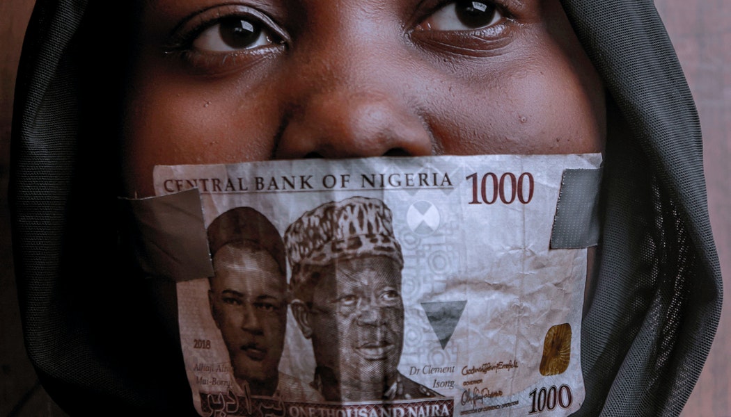 woman covering her mouth with 1000 naira note